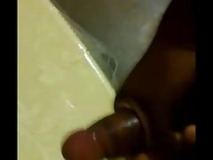 jerking thick ebony pecker to porn cumshot on table